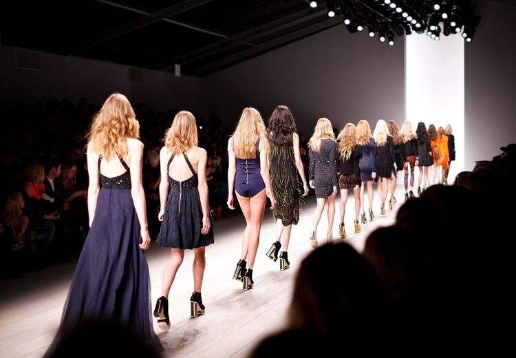 Modellen die een modeshow lopen.